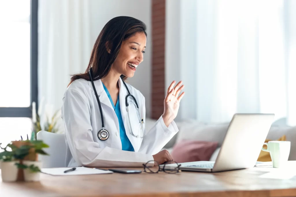 female doctor waving during online consultation at utc