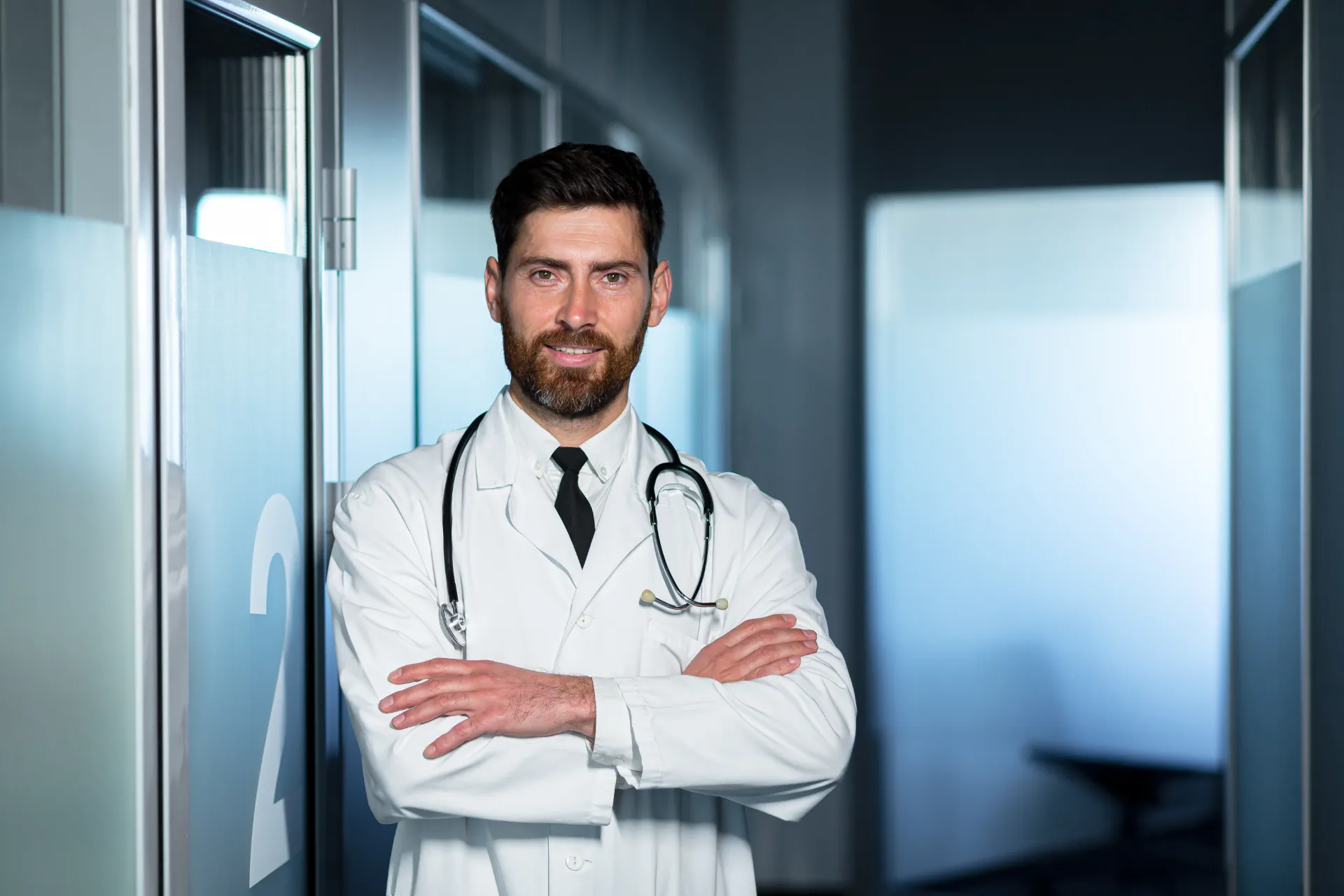 friendly doctor smiling with crossed arms man in utc