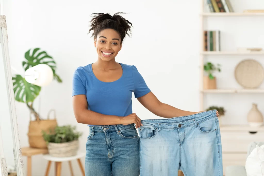 happy slim black woman showing old jeans standing utc webp